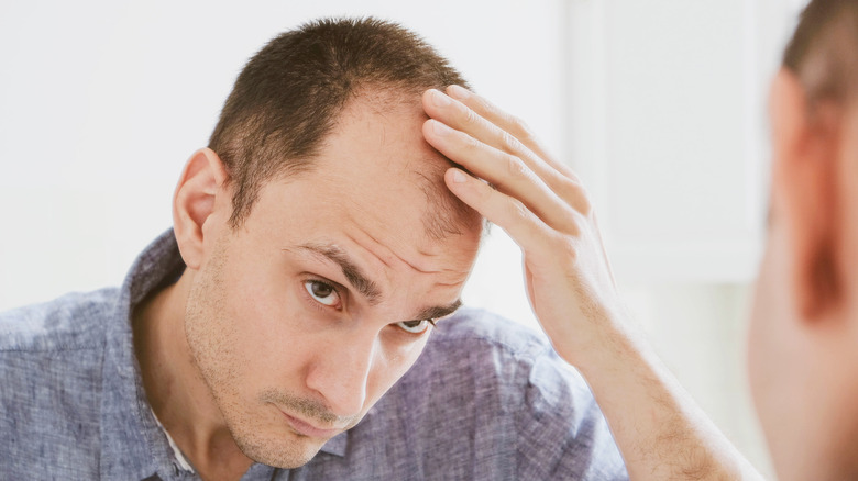 man looking at his hair