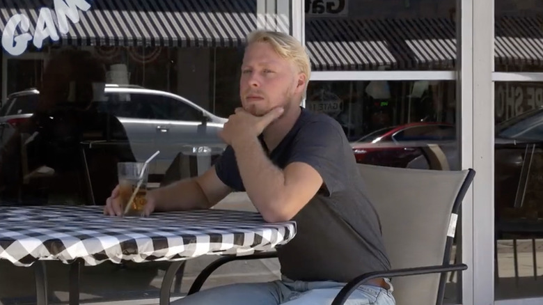 Ethan Plath sitting at a table with a hand on his chin