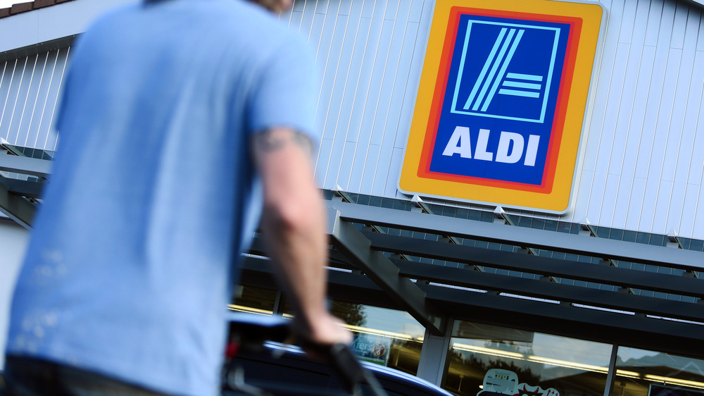 Customer pushing Aldi shopping cart