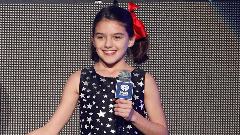 Tween Suri Cruise clutching a microphone 