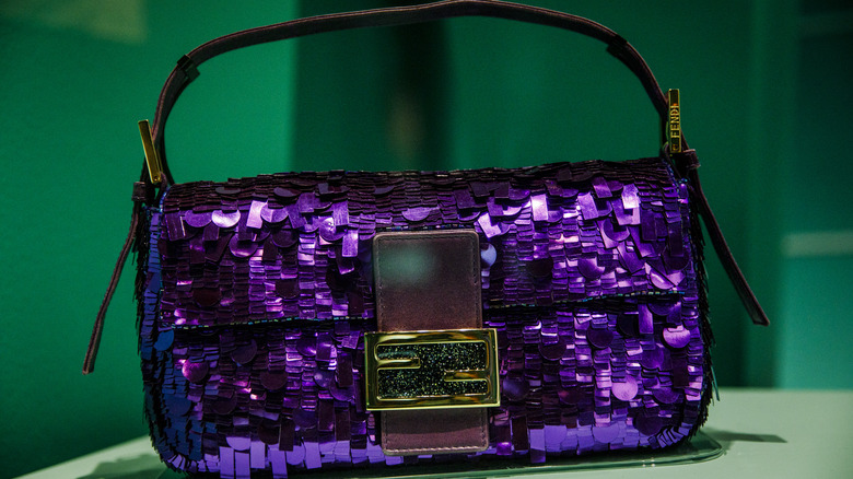 Carrie Bradshaw's purple sequined Fendi baguette bag against green background