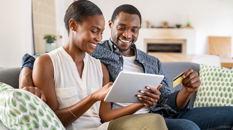 Black couple smiling buying online