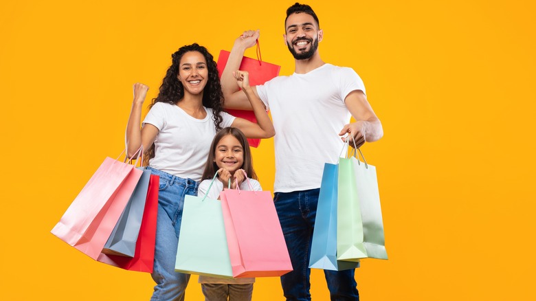 Family holding colorful shopping bags