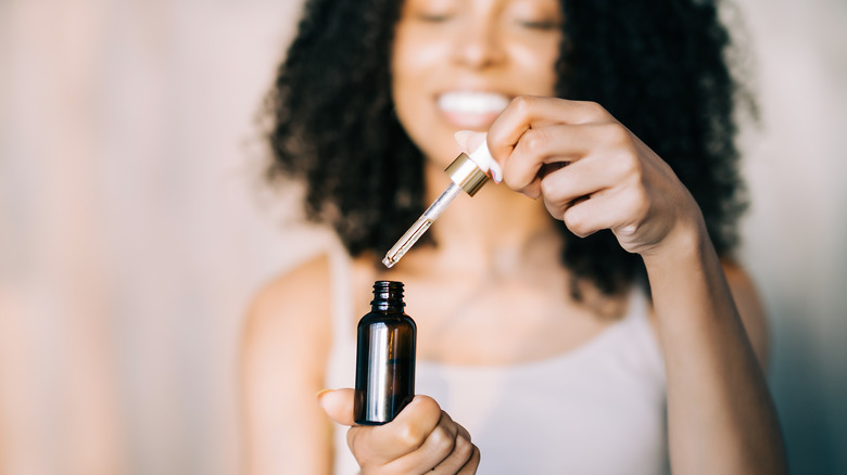 woman holding essential oil bottle