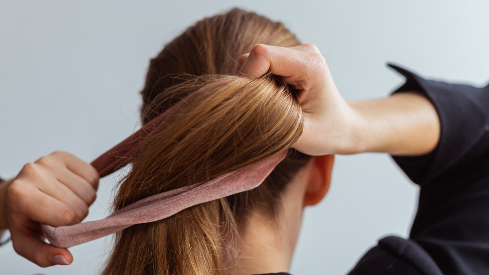 Woman putting her hair into a ponytail