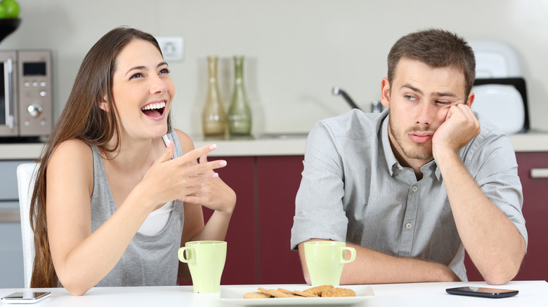 a seated man annoyed with woman