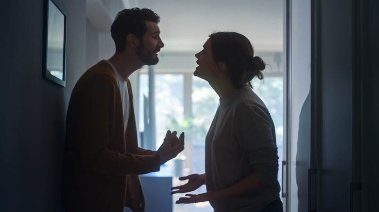 couple arguing in hallway 