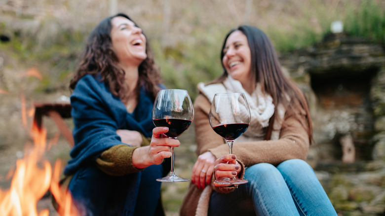 Couple with wineglasses by fireside