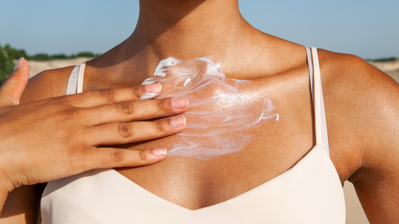 woman applying cream in the sun