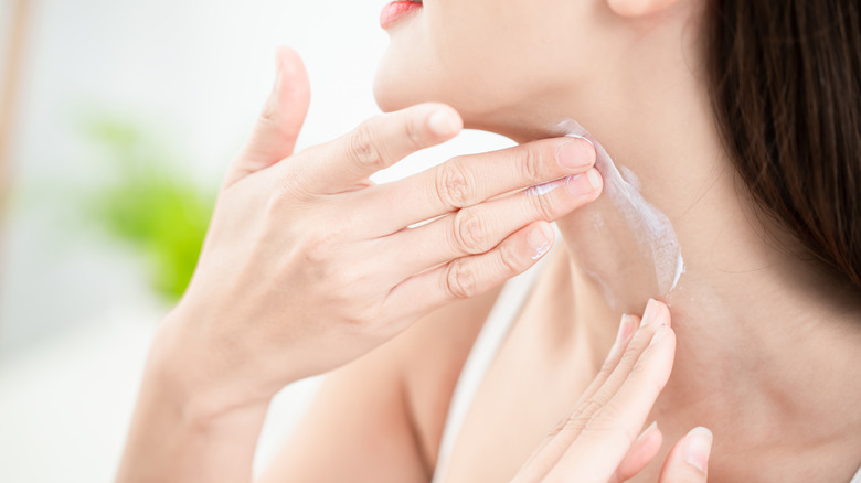 woman applying cream to her neck