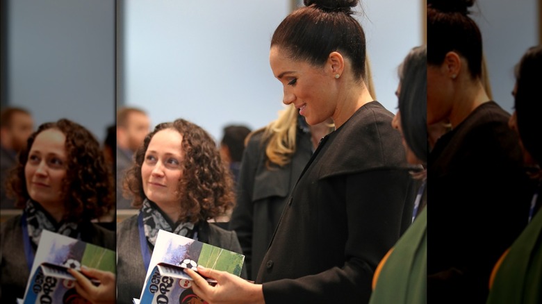 Meghan Markle looking at book