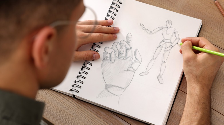 A man drawing in a sketchbook