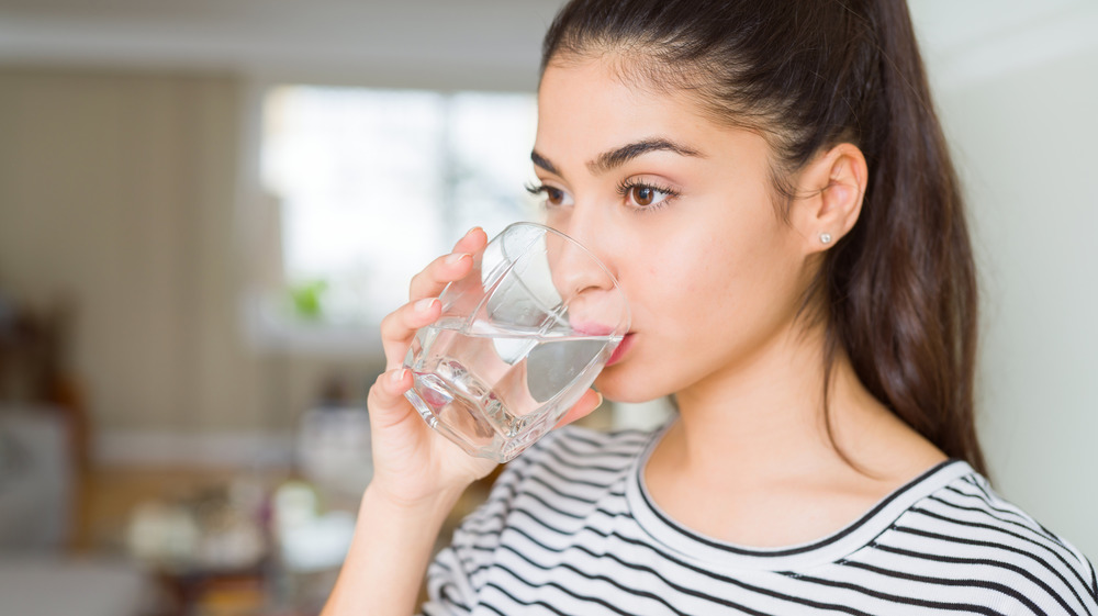 Woman with glowy skin drinking water