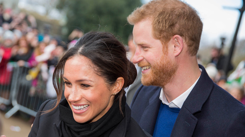 Meghan Markle smiling widely with Prince Harry