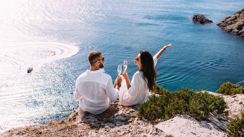 Couple  on vacation sitting on a cliff