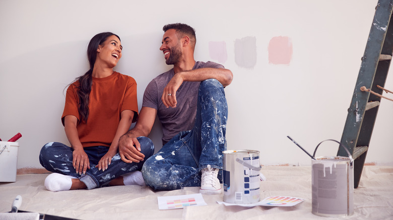 Couple taking a break from painting a wall