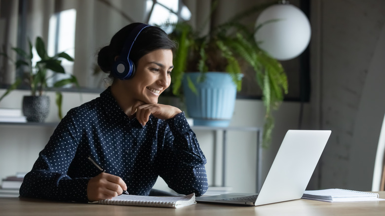 Woman smiling into laptop screen