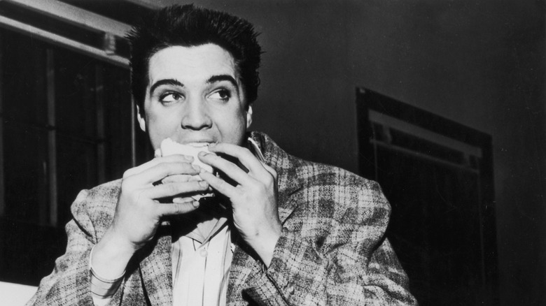 Elvis Presley eating a sandwich