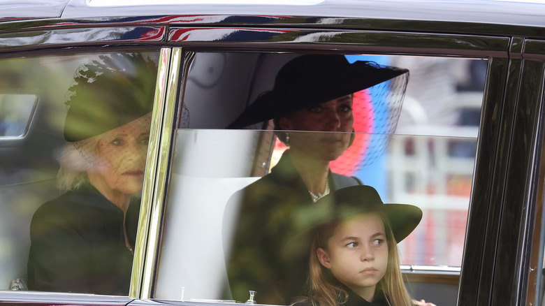 Camilla, Kate and Princess Charlotte of Wales in car during funeral proceedings