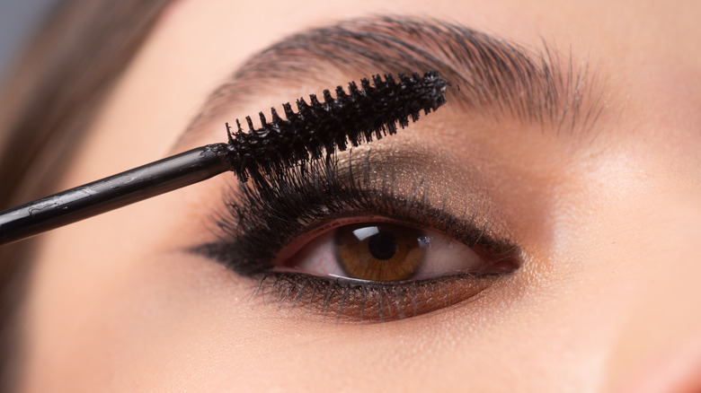 Woman applying mascara