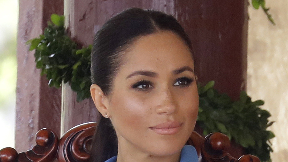 Meghan Markle sits listening during an appearance 