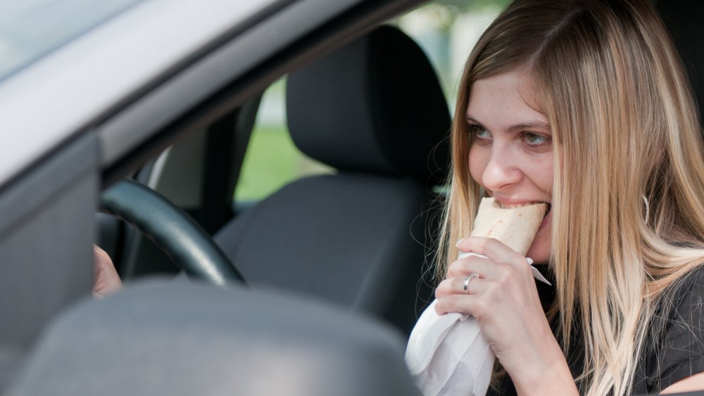 woman eating fast food in car