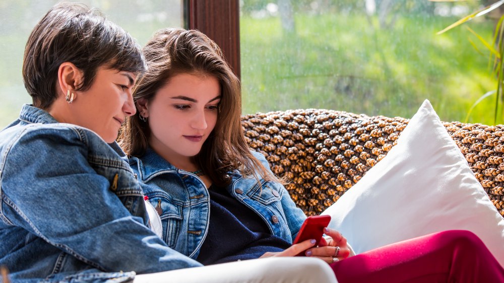 woman and teenager looking at cell phone