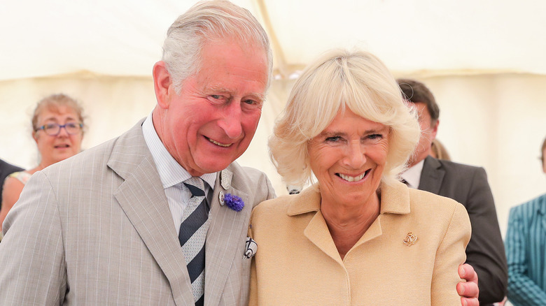 King Charles puts arm around Queen Camilla