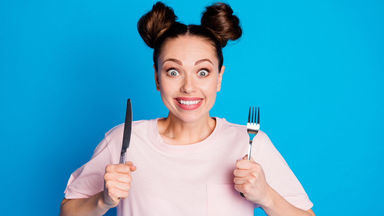 Hungry woman with silverware