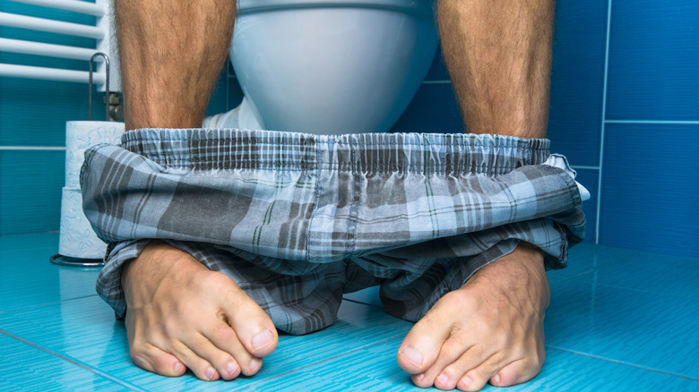 man sitting on toilet