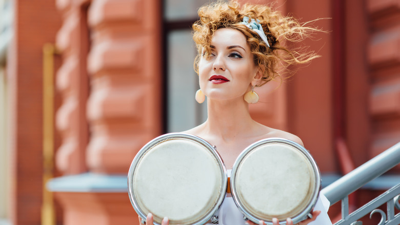 woman holding drums in front of chest