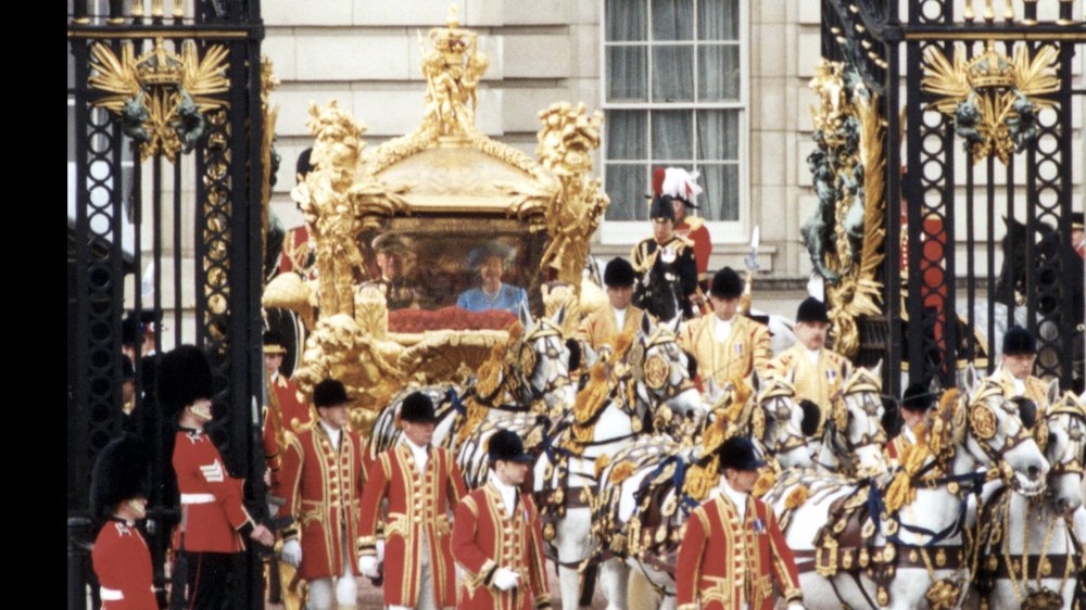 Queen Elizabeth riding in a royal escort, flanked by soldiers and horses