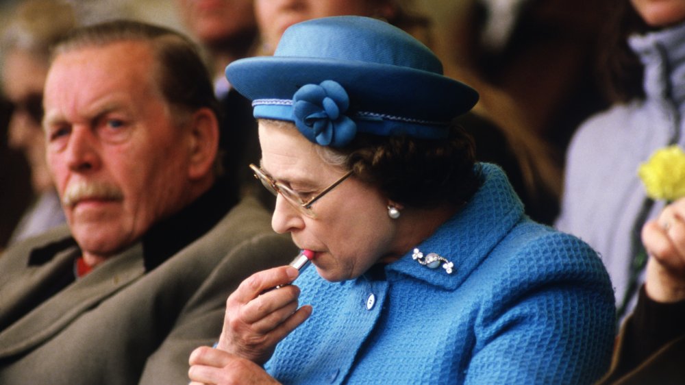 Queen Elizabeth applying lipstick