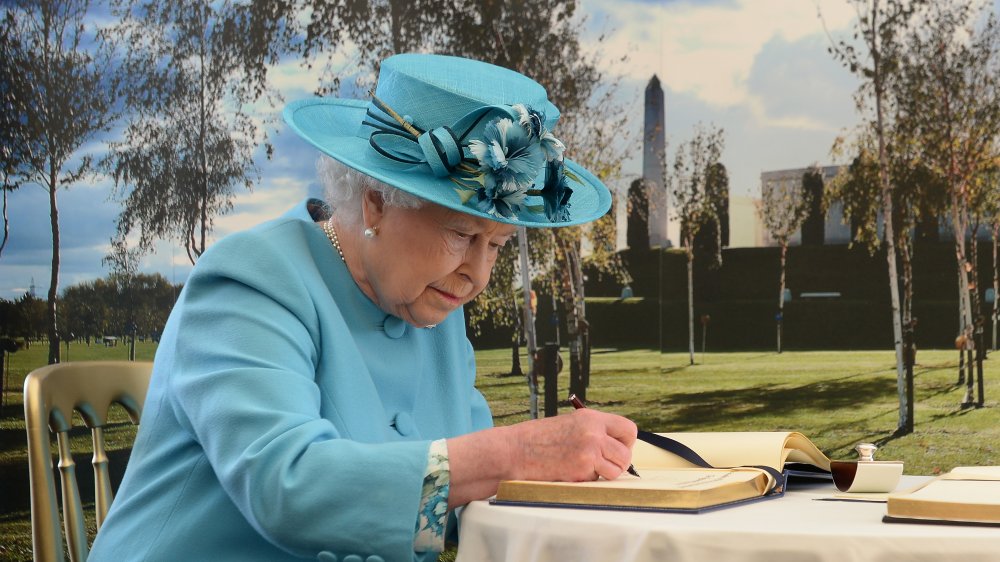 Queen Elizabeth writing in a book