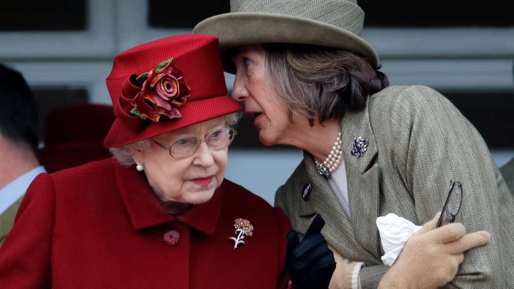 Queen Elizabeth and another royal whispering to one another