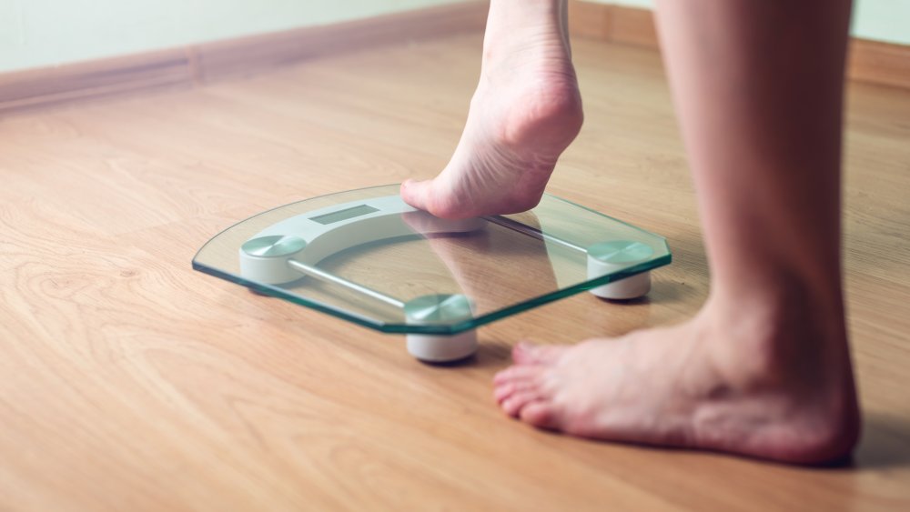 A woman's feet stepping onto a scale