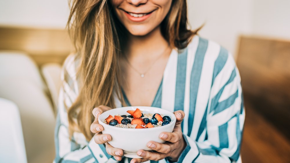 A woman's hands eating breakfast