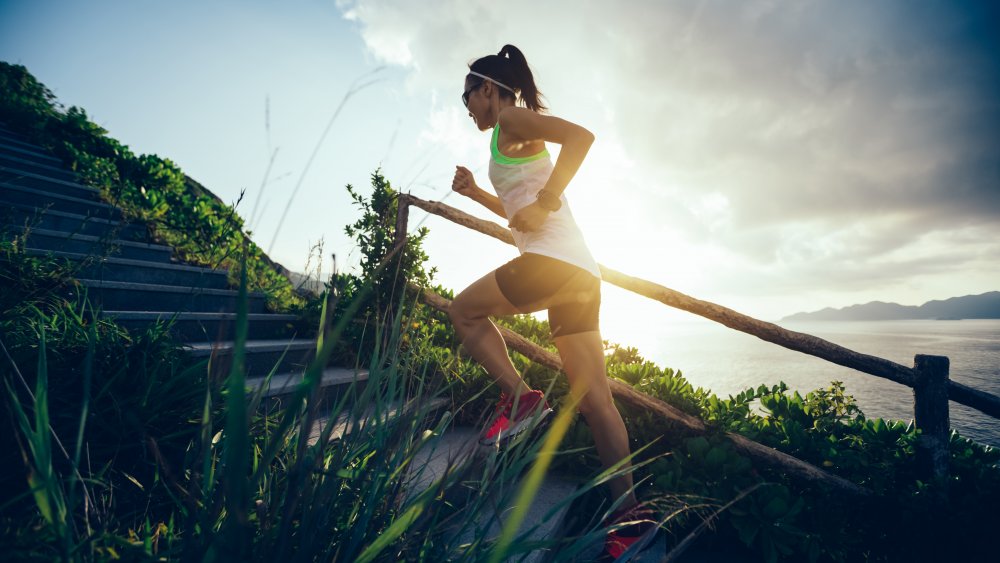 A woman running up stairs by a beach