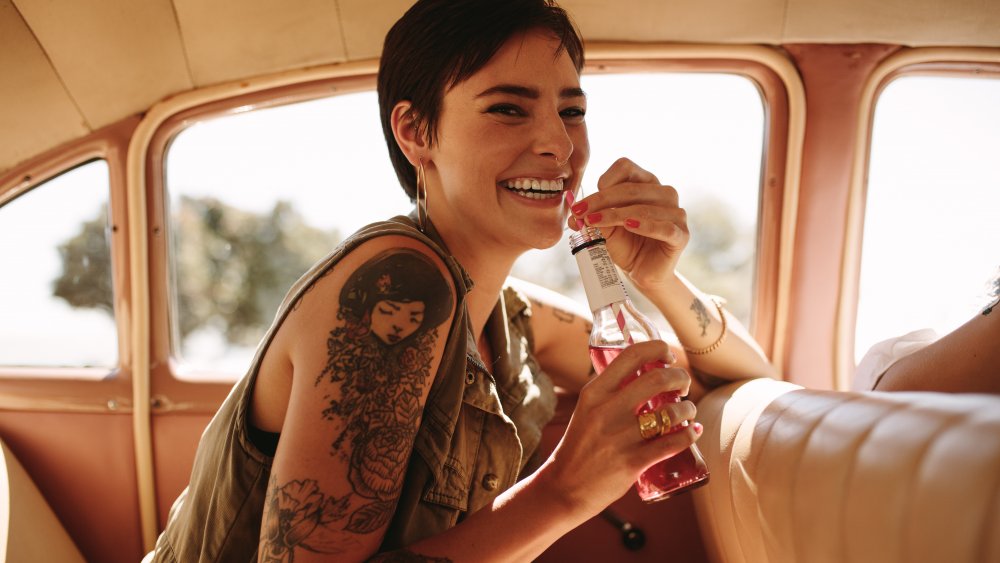 A woman drinking soda in a car