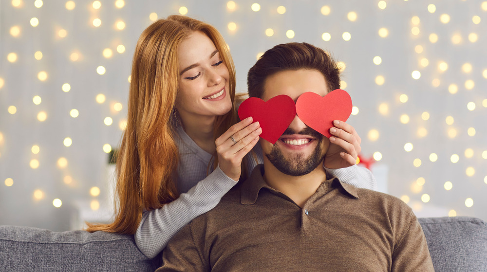 A couple having fun with a heart-shaped card