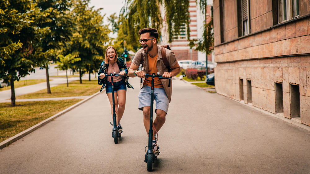 An adventurous couple rides scooters