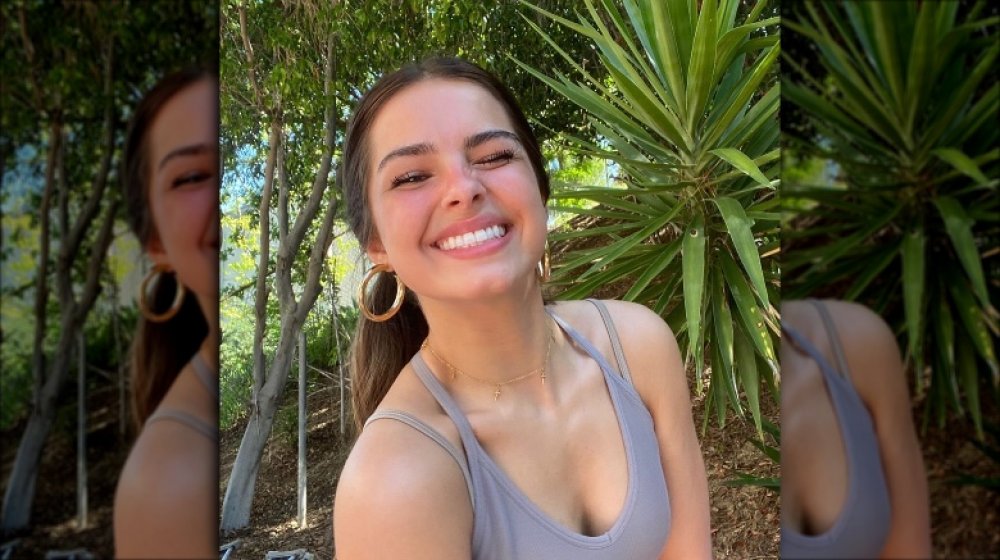 TikTok star Addison Rae smiling in front of greenery