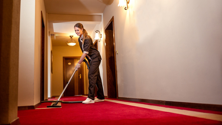 housekeeper vacuuming carpets in hotel