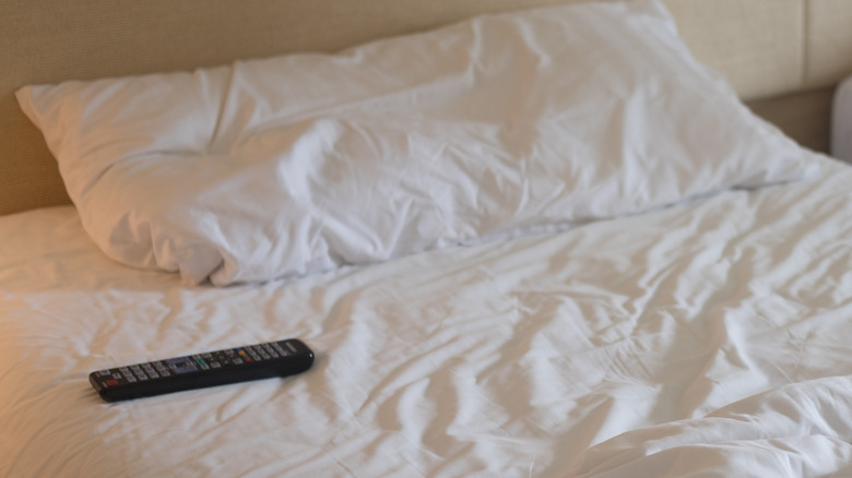 TV remote on hotel room bed, something you should absolutely avoid touching