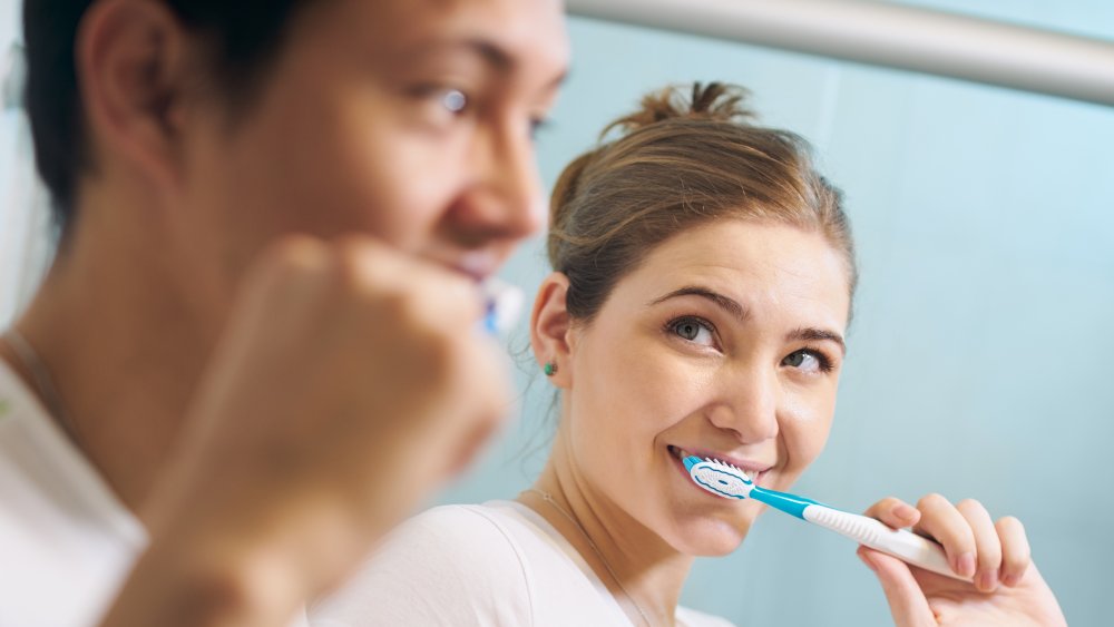 Couple living together brushing their teeth