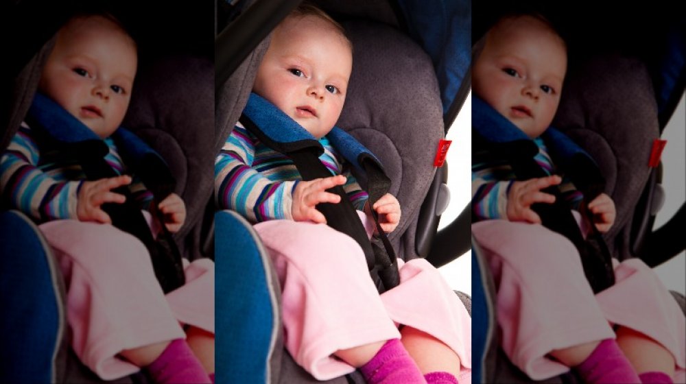 Baby in car seat looking dubious