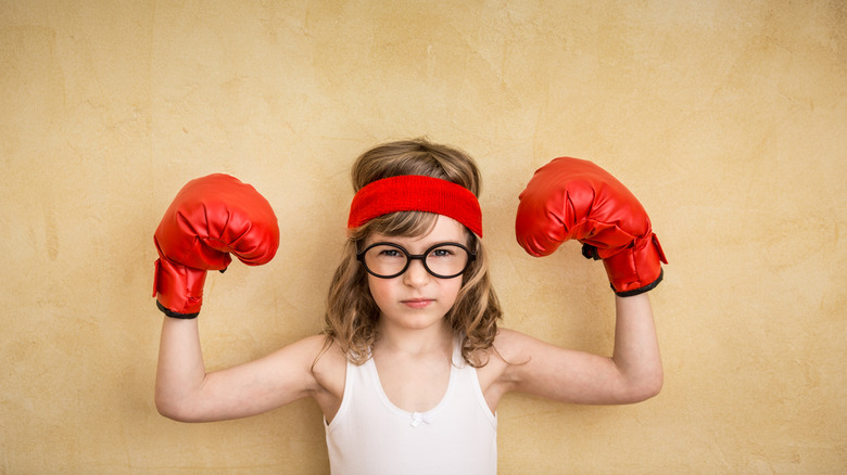 strong kid boxing gloves flexing