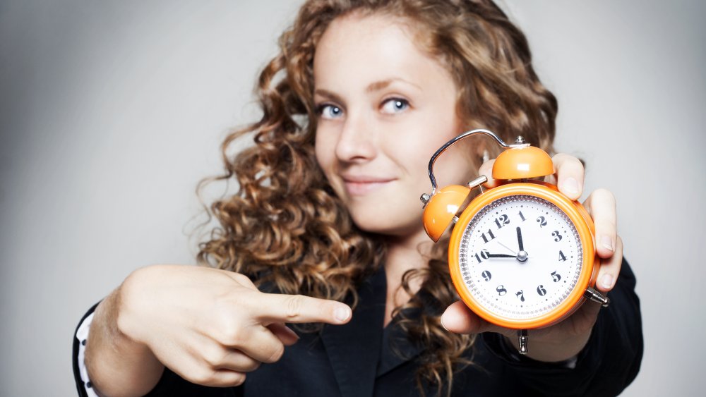 Woman holding a clock