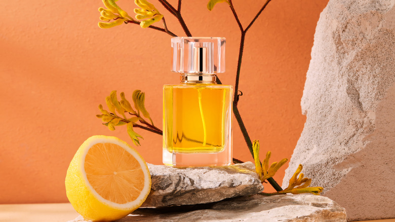 A bottle of perfume and an orange