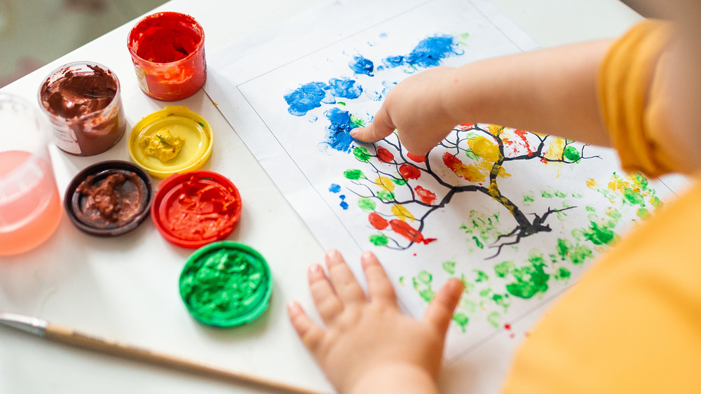 Kid finger painting a tree